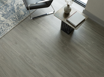 Cathedral SPC vinyl flooring, close view beside a side table, chair and patterned rug.