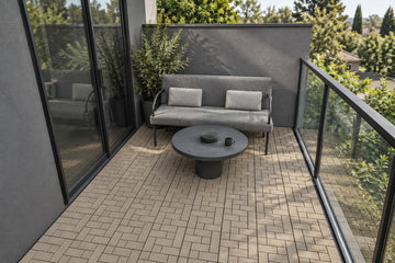 Tan interlocking composite deck tiles in a compact balcony; AI installation visualization guided by the product’s 3D tile model.
