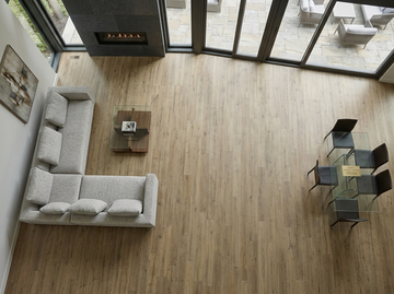 Ceaser SPC vinyl flooring, overhead view of a living room with a sectional sofa and fireplace.