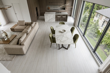 Cornsilk SPC vinyl flooring, shown in an open kitchen, living and dining area with green chairs.