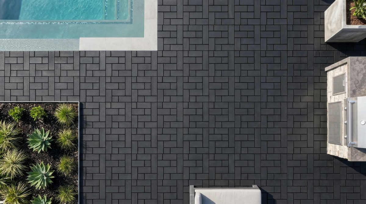 Black interlocking composite deck tiles shown around an outdoor pool.