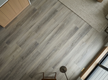 Floating Ice SPC vinyl flooring, close view beside a rug and window.