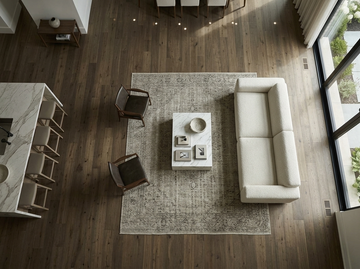 Milk Chocolate SPC vinyl flooring, overhead view around a sofa and rectangular rug.